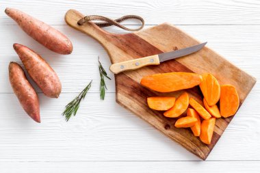 Kesme tahtasında dilimlenmiş tatlı patates, üst manzara.