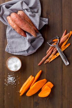 Kesme tahtasında dilimlenmiş tatlı patates, üst manzara.