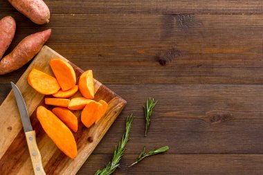 Tatlı patates - dilimlenmiş tatlı patates organik sebzeler kesim tahtasında, yukarıdan manzara