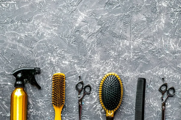 회색 배경 위에서 이발소 도구를 사용하여 머리 모양을 꾸미는 모습 — 스톡 사진