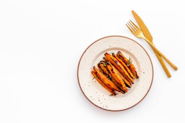 Tabağında otlar olan patates kızartması yığını.