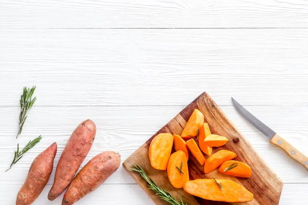 Kesme tahtasında dilimlenmiş tatlı patates, üst manzara.