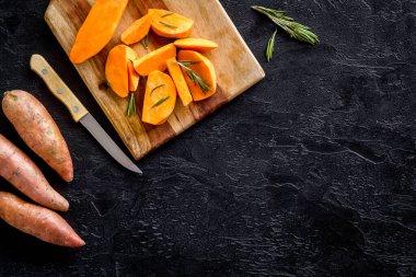 Kesme tahtasında çiğ portakallı tatlı patates, üst manzara.