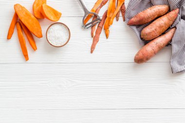 Kesme tahtasında dilimlenmiş tatlı patates, üst manzara.