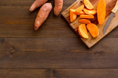 Kesme tahtasında dilimlenmiş tatlı patates, üst manzara.