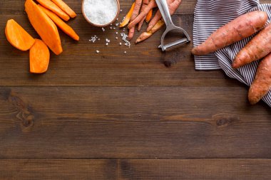 Kesme tahtasında çiğ portakallı tatlı patates, üst manzara.