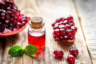 Dilimlenmiş nar ve ahşap zemin üzerinde cam özü.