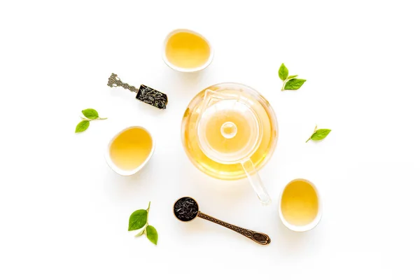 Tea green leaves with teapot and cups, top view. Tea ceremony concept. — Stock Photo, Image