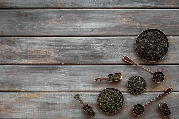 Puesta plana de hojas de té seco en cuencos y cucharas. Concepto de té. Vista superior —  Fotos de Stock