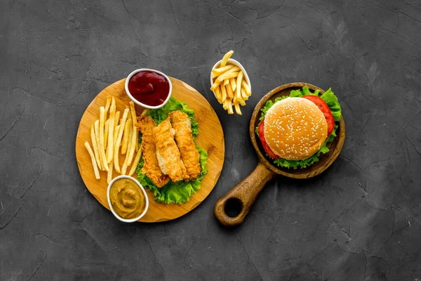 Top view of delicious burgers on on wooden board. Fried potatoes and chicken — Stock Photo, Image