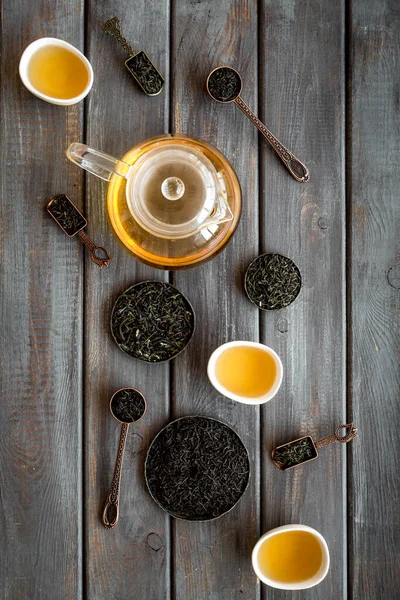 Konzept der Teezeremonie. Heißer und trockener Tee in Teekanne und Tassen, Draufsicht — Stockfoto