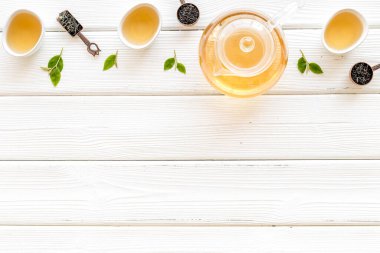 Çaydanlık ve fincanla yeşil çay yaprakları, üst manzara. Çay töreni konsepti.