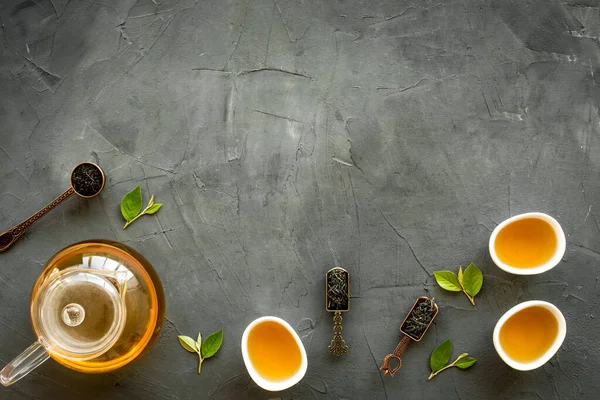 Zielone liście herbaty z czajniczek i kubki, widok z góry. Pojęcie ceremonii herbaty. — Zdjęcie stockowe