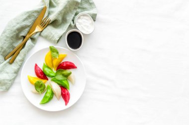 Buharda pişirilmiş hamur tatlısı manzarası. Sebze mantısı beyaz tabakta.