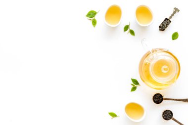 Çaydanlık ve fincanla yeşil çay yaprakları, üst manzara. Çay töreni konsepti.