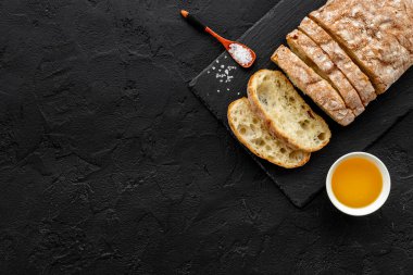 Kesme tahtasında yağlı dilimlenmiş ciabatta ekmeği.