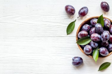 Olgun bahçe erikleri kasede. Yapraklı kiraz meyvesi. Üst görünüm