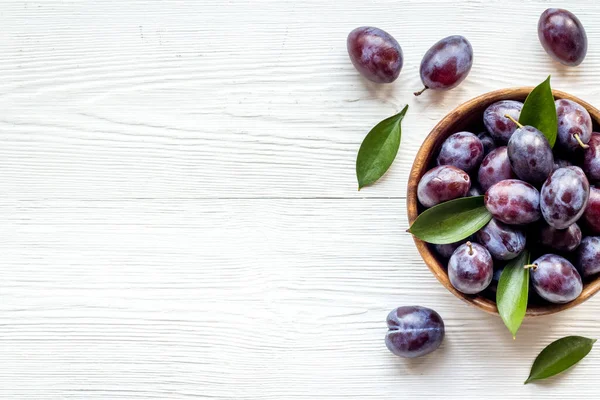 Olgun bahçe erikleri kasede. Yapraklı kiraz meyvesi. Üst görünüm