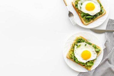 Avokado tostları ve kızarmış yumurtalarla kahvaltı.
