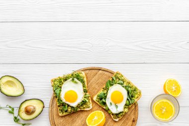 Avokado tostları ve kızarmış yumurtalarla kahvaltı.