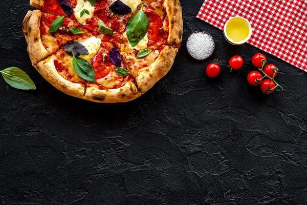 Domates peyniri ve fesleğenle dilimlenmiş İtalyan pizzası.