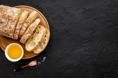 Kesme tahtasında yağlı dilimlenmiş ciabatta ekmeği.