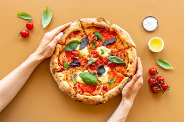 İtalyan pizzalı kadın eli margherita, üst manzara.