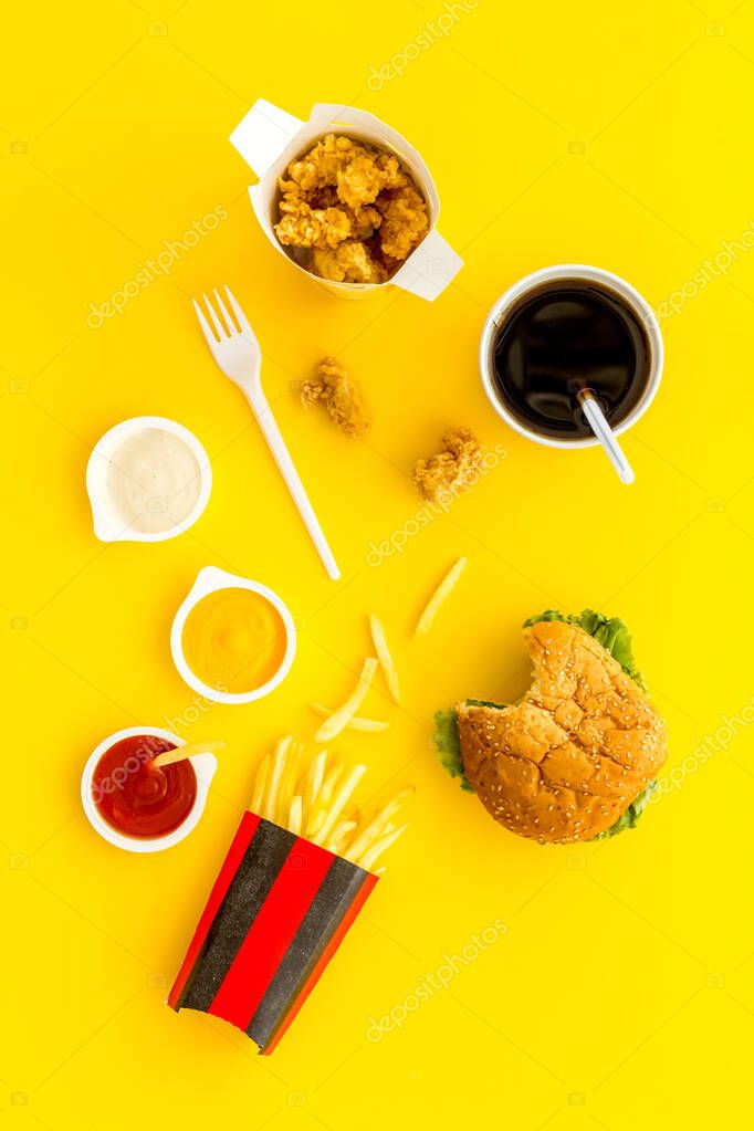 Junk fat food snack - french fries and burger, top view.