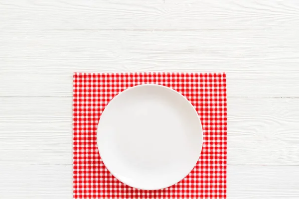 Пустая тарелка на салфетке - сервировка стола к ужину. Вид сверху — стоковое фото