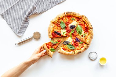 Kadın eli bir dilim pizzayı tutuyor. Genel Görünüm