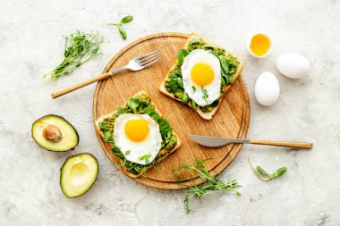 Avokado tostları ve kızarmış yumurtalarla kahvaltı.