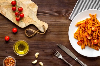 Bir tabak makarna, domates sosu ve otlu makarna.