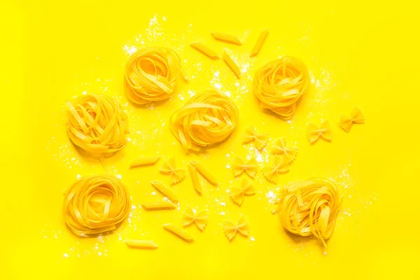 Verschillende tipes pasta met meel klaar om te koken, plat gelegd — Stockfoto