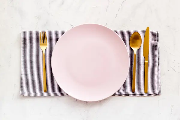 Weißer Teller mit Gabel und Messer auf Tischserviette. Tisch gedeckt — Stockfoto