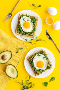 Yumurta ve avokado, kızarmış ekmeğin üzerinde ıspanak. Üst görünüm
