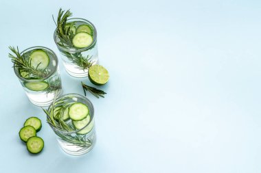 Limon dilimleri, salatalık ve biberiyeli taze soğuk kokteyl.