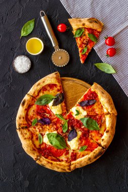 Domates peyniri ve fesleğenle dilimlenmiş İtalyan pizzası.