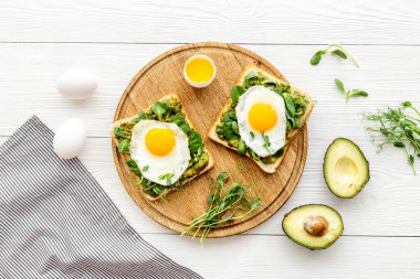 Avokado tostları ve kızarmış yumurtalarla kahvaltı.