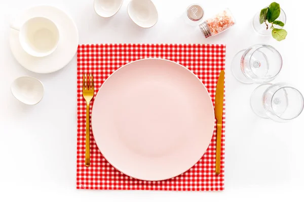 Посуда с пустой тарелкой с посудой и стаканами на салфетке — стоковое фото