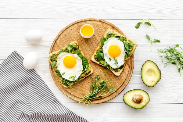 Avokado tostları ve kızarmış yumurtalarla kahvaltı.