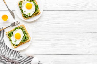 Yumurta ve avokado, kızarmış ekmeğin üzerinde ıspanak. Üst görünüm