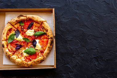 Domates peyniri ve fesleğenle dilimlenmiş İtalyan pizzası.