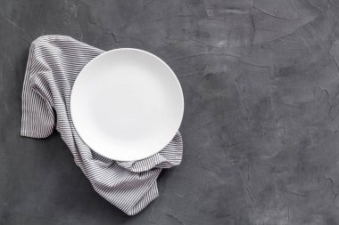 Akşam yemeği için masayı hazırla. Peçeteye boş tabak - bulaşık takımı üst görünümü