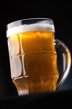 Büyük bardak bira karanlık bir arka plan üzerinde