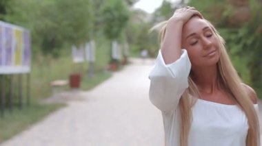 Doğal makyaj güzel bir genç kadın uzun saçlı park arka plan üzerinde portresi