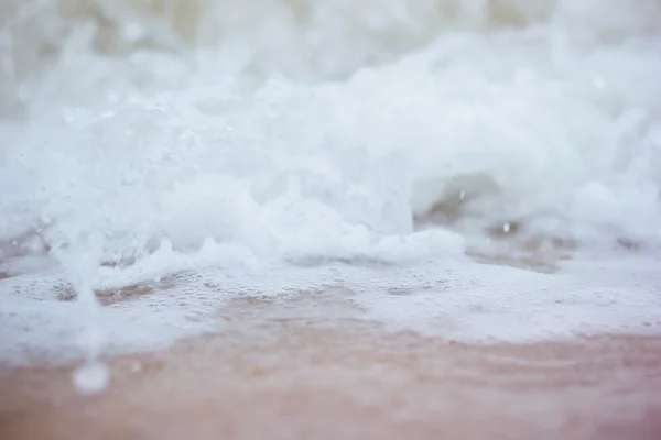 Clima frío y ventoso en el mar. Olas marinas en una costa arenosa. spray de mar y espuma — Foto de Stock