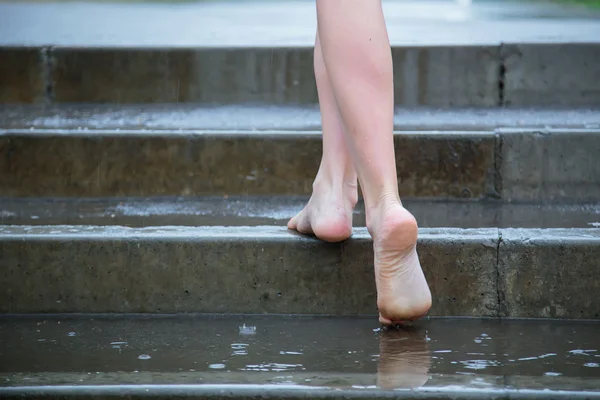 Jeune belle caucasienne blonde en short et chemise marchant dans le parc sous la pluie chaude estivale pieds nus à travers les flaques d'eau. Amusez-vous bien. Pluie tombante. Des gouttes de pluie. Vêtements humides — Photo