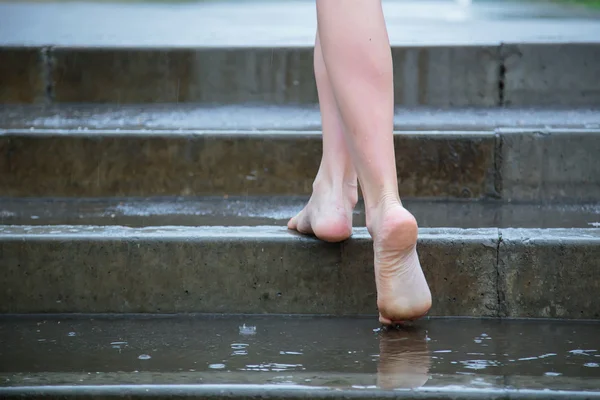 Joven hermosa rubia caucásica chica en pantalones cortos y camisa caminando en el parque en el verano cálida lluvia descalza a través de los charcos. Diviértete y disfruta. Lluvia cayendo. Gotas de lluvia. Ropa mojada — Foto de Stock