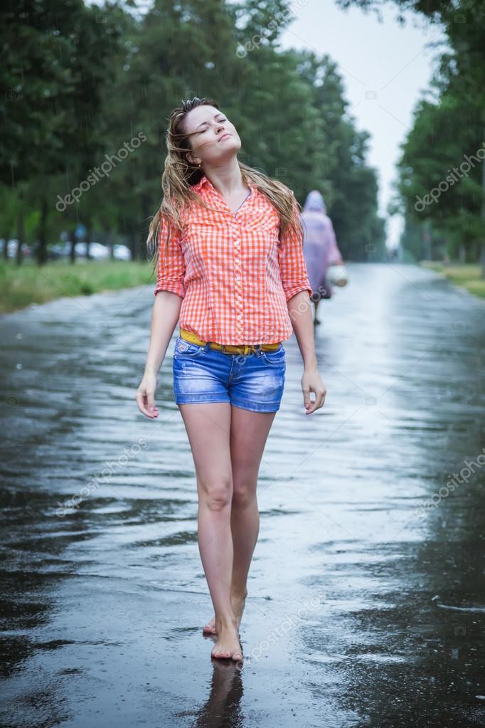 Young beautiful blond caucasian girl in shorts and shirt walking