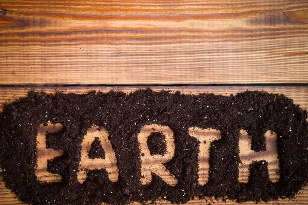 Parole de la Terre sur une table en bois posée hors de la couche arable. Espace vide. Jour de la Terre. — Photo